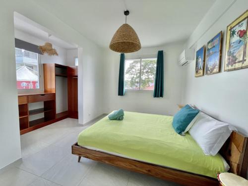樂迪亞曼特的住宿－Villa en bord de mer, vue mer au Diamant，一间位于客房内的带绿床的卧室
