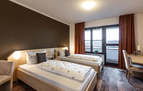 Habitación de hotel con 2 camas, mesa y escritorio en Brauereigasthof Hofmark, en Lenting