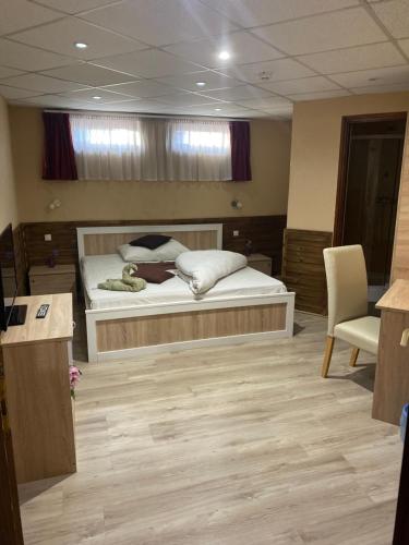 a bedroom with a bed and a desk and a chair at Abszolút Hotel és Panzió in Nyírbátor