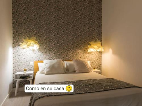 a bedroom with a bed with a patterned wall at Moderno apartamento en casco histórico + desayuno! in Zaragoza