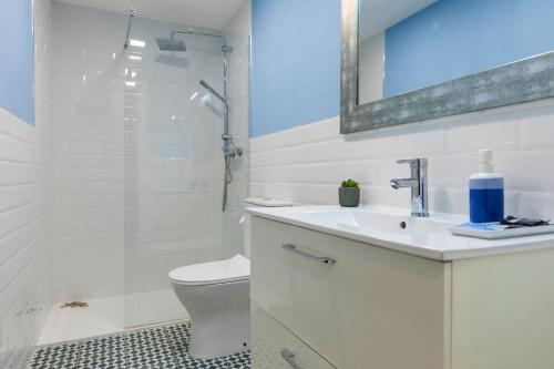 a bathroom with a toilet and a sink and a shower at Moderno apartamento en casco histórico + desayuno! in Zaragoza