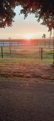 a fence in a field with the sunset in the background at Vledderstee in Vledderveen