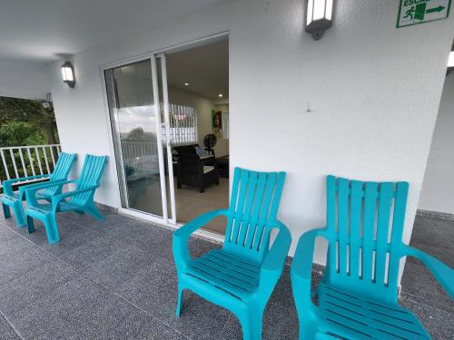 three blue chairs sitting around a table on a balcony at Red Snapper Guest House in Providencia