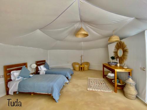 a bedroom with two beds and a tent at Tuda Luxury Camp in Merzouga