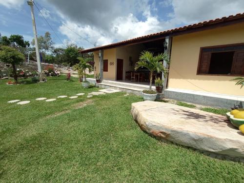 einen Hinterhof eines Hauses mit einem Rasenplatz in der Unterkunft CASA DE CAMPO SENHORA SANTANA in Rio de Contas