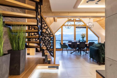 a dining room with a staircase and a dining table at udanypobyt Apartamenty Czorsztyn Panorama 2 B in Czorsztyn