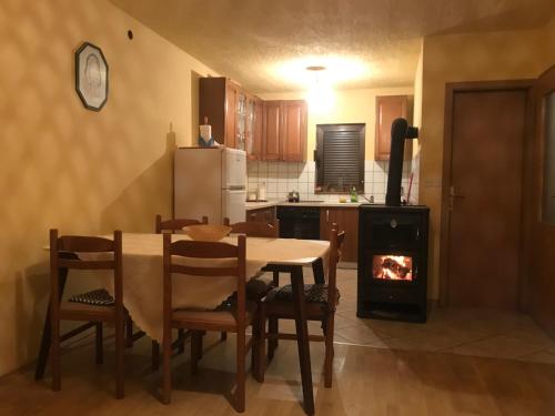 een keuken met een tafel en een houtkachel bij Mountain House Vinko in Blidinje