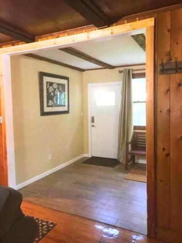 a living room with a door open to a room at Rare River Views & Access, Cabin by Eden Islands in Montague