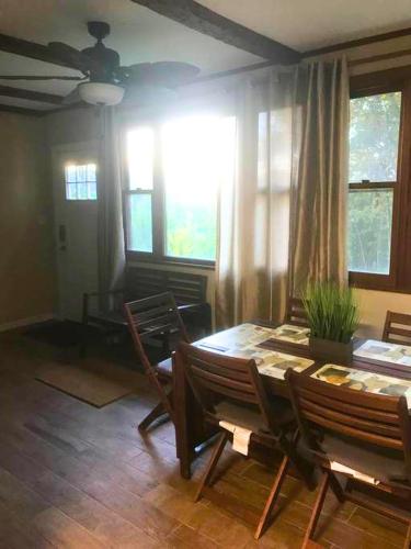 a dining room with a table and chairs and windows at Rare River Views & Access, Cabin by Eden Islands in Montague