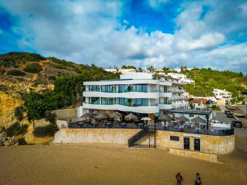 a large white building on the beach near the ocean at Villamar in Salema