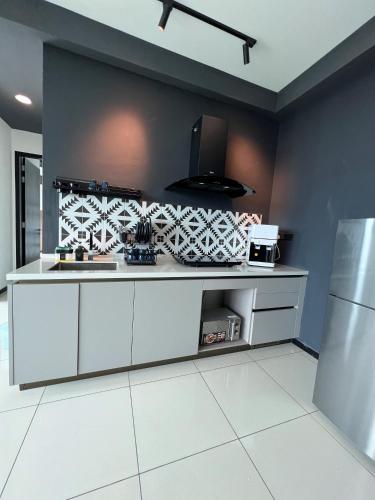 a kitchen with white cabinets and a black wall at Opus Residence KL by EUcation Home in Kuala Lumpur