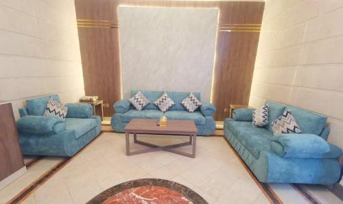 salon z 2 niebieskimi kanapami i stołem w obiekcie سارة للشقق المفروشة - الحمدانية جدة w mieście Ḩayy aş Şāliḩīyah