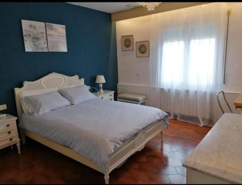 a bedroom with a bed and a blue wall at Spacious family flat centrally located. in Palamós