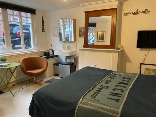 a bedroom with a bed and a sink and a mirror at Obrecht Welcome in Utrecht