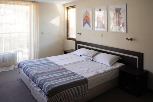 a bedroom with a large bed in a room with a window at Meteor Family Hotel in Chepelare