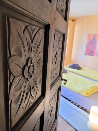 a wooden door with a flower etched into it in a bedroom at Vista dolce - Wohnung mit fabelhaftem Blick über die Dächer von Brissago in Brissago