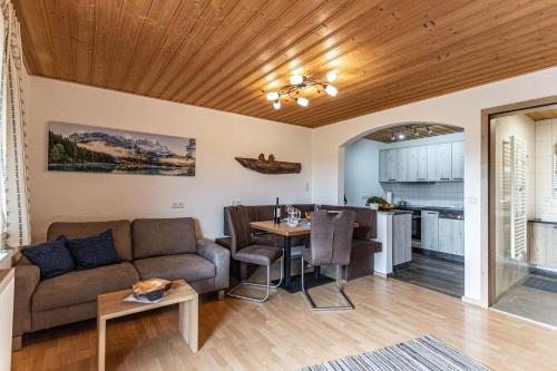 a living room with a couch and a table at Trollenhof im Allgäu - Ferienwohnungen Aggenstein in Rückholz