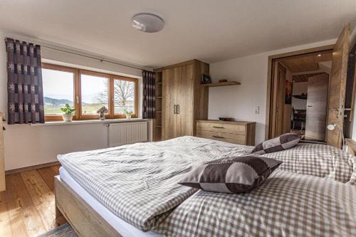 Un dormitorio con una cama grande y una ventana en Trollenhof im Allgäu - Ferienwohnungen Aggenstein, en Rückholz