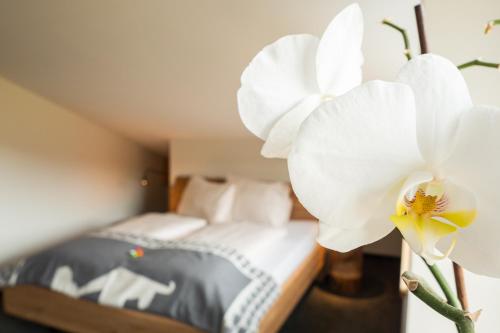 a bedroom with a bed and a large white orchid at Alte Bildhauerei in Aurach bei Kitzbuhel