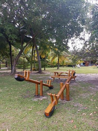 a group of wooden benches in a park at Vizinho à igrejinha - Apartamento completo no ECO RESORT Praia dos Carneiros in Praia dos Carneiros