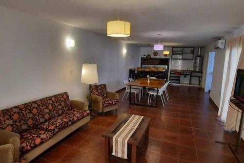 ein Wohnzimmer mit einem Sofa und einem Tisch in der Unterkunft Casa en Bosque Peralta Ramos in Mar del Plata