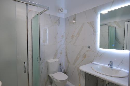 a bathroom with a shower and a toilet and a sink at Sunny Holiday in Sarandë