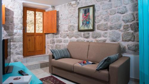 a living room with a couch and a stone wall at Imperia - Chic! place with balcony in Dubrovnik