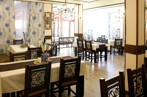 a dining room with tables and chairs in a restaurant at Meteor Family Hotel in Chepelare