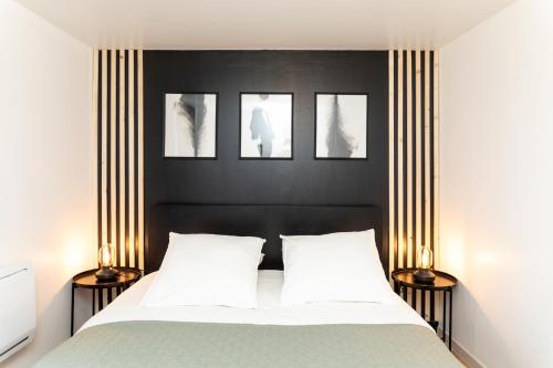 a bedroom with a bed with three pictures on the wall at Le Factory : Proche Roissy CDG - Paris - Astérix in Moussy-le-Neuf