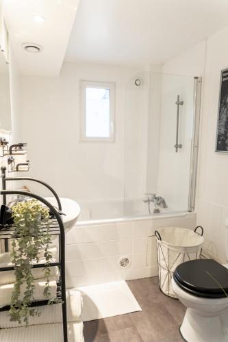 une salle de bain blanche avec toilettes et baignoire dans l'établissement Le Factory proche aéroport CDG I Paris I Astérix, à Moussy-le-Neuf