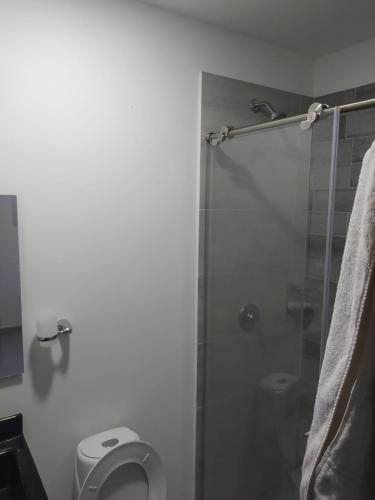 a bathroom with a toilet and a glass shower at Hermoso aparta estudio con Aire Acondicionado en un primer piso Cerca al Hospital de Neiva in Neiva