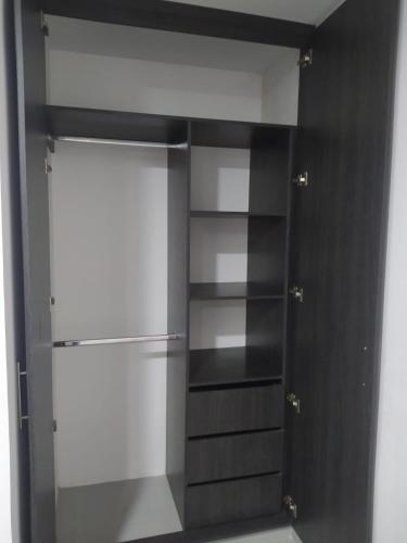 een kast met zwart-witte planken en een koelkast bij Hermoso aparta estudio con Aire Acondicionado en un primer piso Cerca al Hospital de Neiva in Neiva