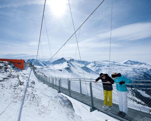 two people standing on a suspension bridge in the snow at Johannesbad Hotel Palace - Kinder bis 11 kostenfrei in Bad Hofgastein