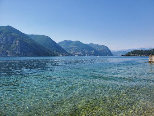 a large body of water with mountains in the background at Camping Pilzone in Iseo