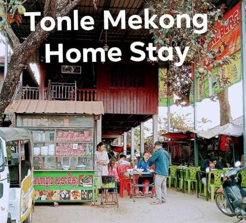 una casa con gente sentada en mesas delante de ella en Tonle Mekong Homestay, en Krong Kracheh