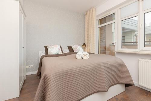 華沙的住宿－Błonia Wilanowskie Apartment Warsaw by Renters，一间卧室配有一张床,上面有两条毛巾