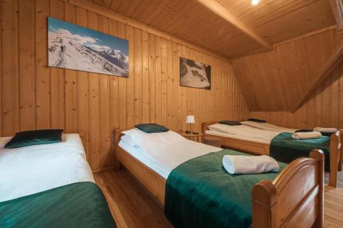 a room with three beds in a cabin at Tatrzański 22 - Komfortowy dom w górach in Leśnica