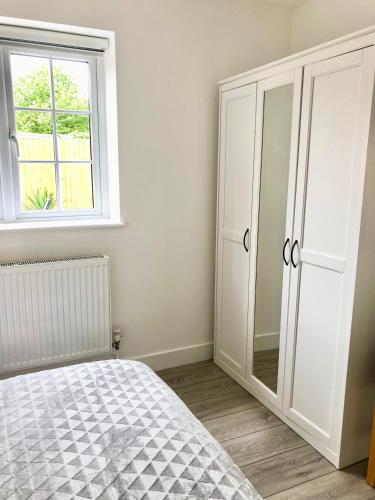 a bedroom with a bed and a window at Spacious En-suite Private Double Bedroom in Oxford