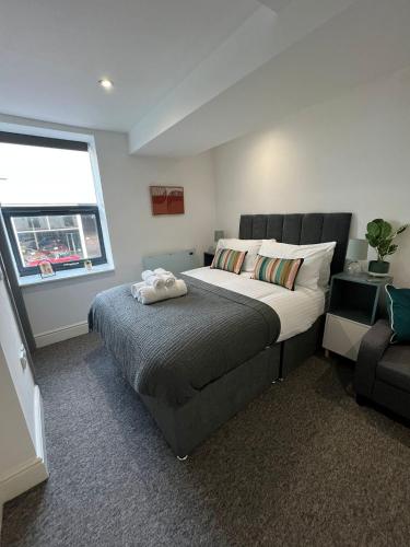 a bedroom with a large bed and a window at Guest Homes - Eign Street Apartments in Hereford