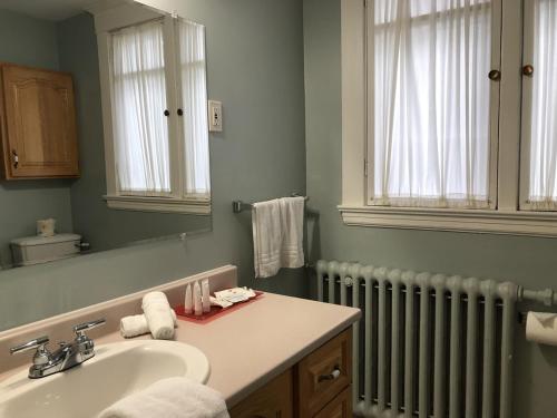 La salle de bains est pourvue d'un lavabo et d'un radiateur. dans l'établissement Leaside Executive Apartments, à Saint-Jean