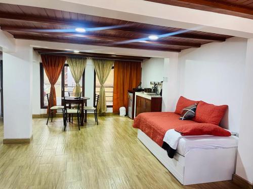バーニョスにあるHermoso apartamento en Baños de Agua Santaのベッドルーム1室(ベッド1台付)、ダイニングルーム(テーブル付)