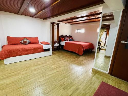 1 dormitorio con 2 camas y espejo en Hermoso apartamento en Baños de Agua Santa, en Baños