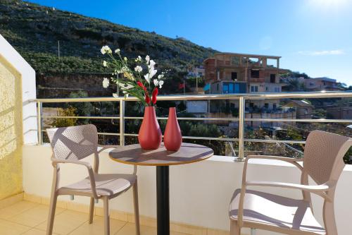 a table with two red vases on top of a balcony at Sunny Holiday in Sarandë