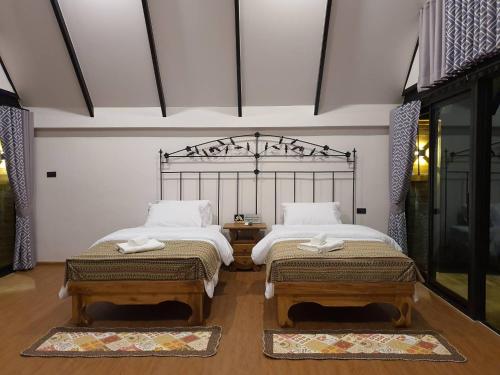 two twin beds in a room with at Oxy Resort in Ban Mai Phatthana