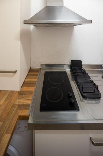 a kitchen with a stove top in a refrigerator at Cal Xesc in Castellar de NʼHug