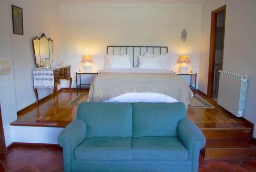 a bedroom with a bed with a blue couch in it at Casa da Reina in Viana do Castelo