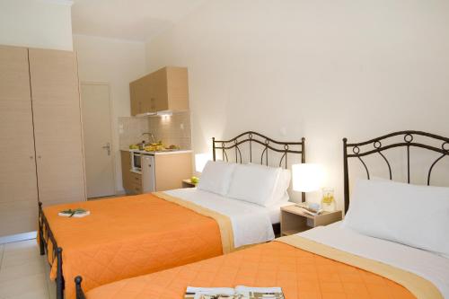a hotel room with two beds and a kitchen at Anemolia Apartments in Vasiliki