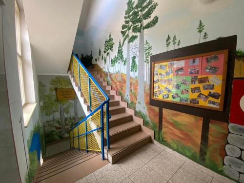 a staircase in a building with a mural on the wall at Středisko ekologické výchovy SEVER in Horní Maršov