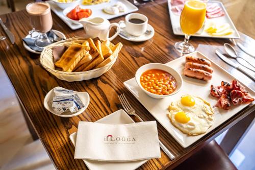 uma mesa de madeira com comida e bebidas para o pequeno-almoço em Il-Logga Boutique Hotel em Xaghra