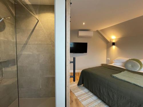 a bedroom with a bed and a glass shower at Hotel-restaurant "Lely" in Oude-Tonge